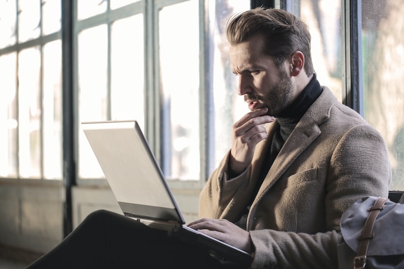 Ein Mann schaut skeptisch auf seinen Laptop-Bildschirm. Nun verraten wir Ihnen, wie die Jahresabrechnung für eine WEG aussehen und was sie beinhalten muss.