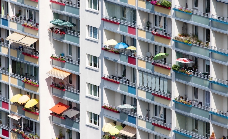 Ein Wohnblock mit farbenfrohen Balkons. Wir verraten Ihnen jetzt, von wem Eigentümer bei einer Eigentümerversammlung vertreten werden können.
