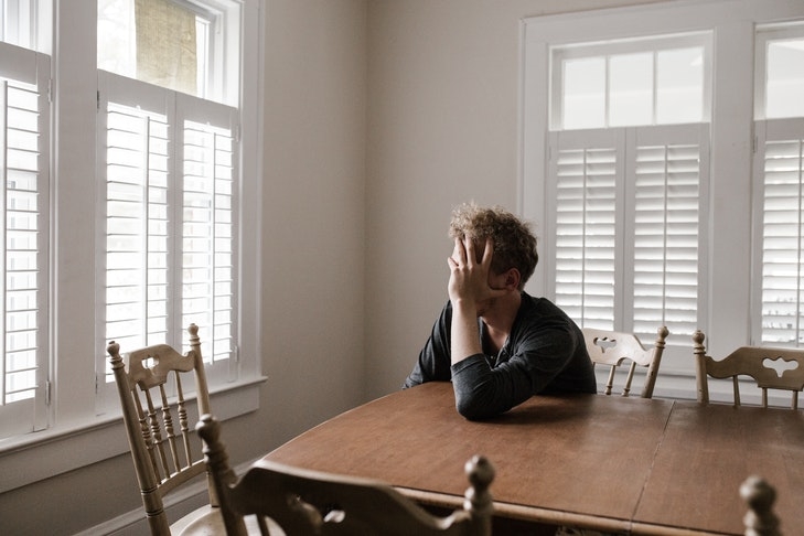 Ein Mann sitzt an einem Tisch in einer Wohnung und rauft sich die Haare. Wenn teure Sonderumlagen auf Wohnungseigentümer zukommen, kann es für viele Eigentümer finanziell eng werden. Daher ist eine realistisch bemessene Instandhaltungsrücklage sehr wichtig.