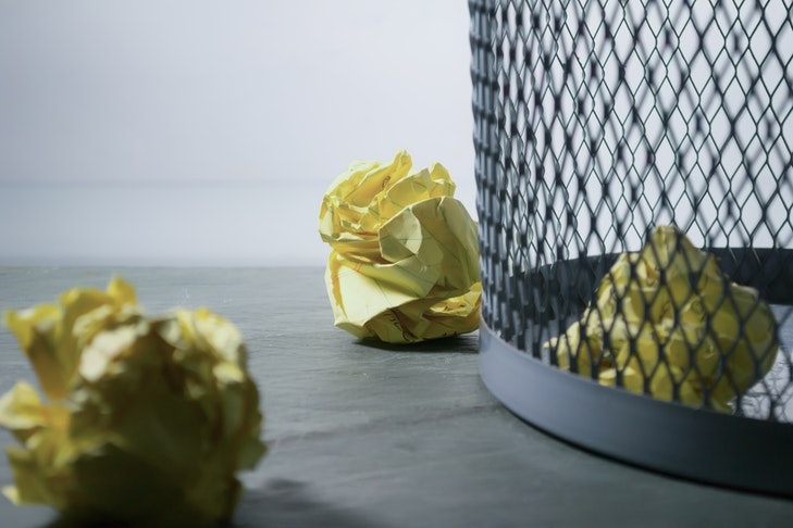 Ein Papierkorb mit mehreren zerknüllten Blättern ist zu sehen. Wenn Wohnungseigentümer nicht auf einen Umlaufbeschluss reagieren, kann dieser nicht zustande kommen, da die Zustimmung aller Eigentümer erforderlich ist.